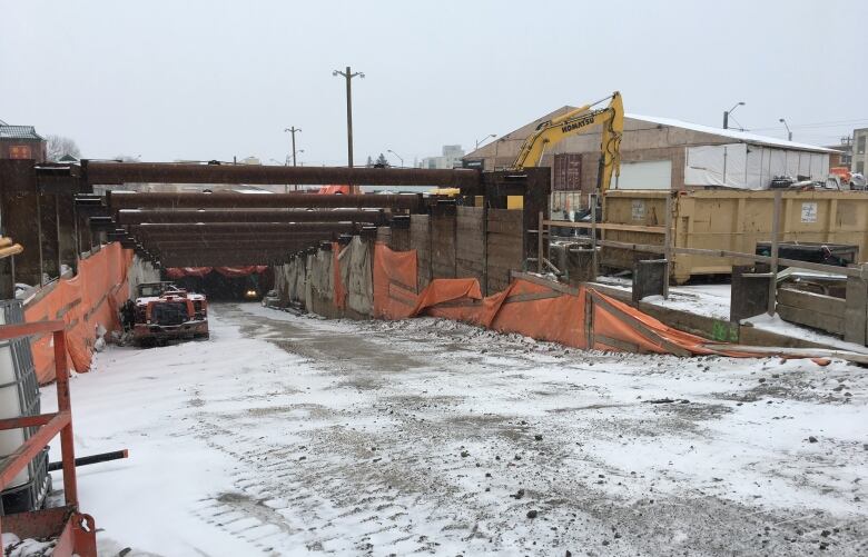 A construction site showing the sloping entrance down into a tunnel.