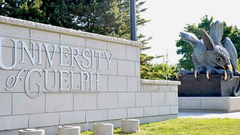 University of Guelph sign next to a gryphon statue