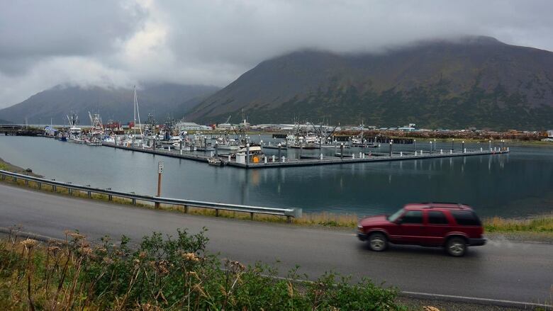 In this Sept. 23, 2013, file photo, a driver passes a small boat harbor in King Cove, Alaska. Interior Secretary Ryan Zinke signed a land exchange agreement Monday, Jan. 22, 2018, authorizing a swap of federal land in Izembek National Wildlife Refuge for land owned by King Cove Corporation that could lead to a road through the refuge so King Cove residents can have land access to an all-weather airport at Cold Bay, Alaska.