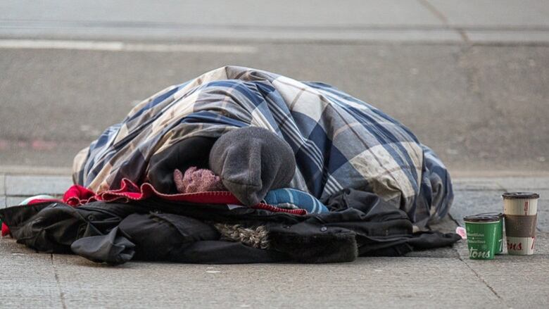 A person sleeping in the street in Toronto.