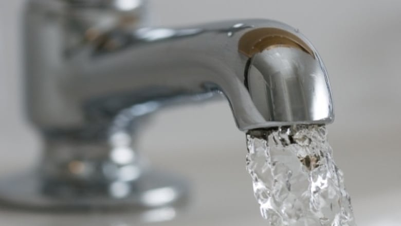 a close up of a water faucet with water coming out.