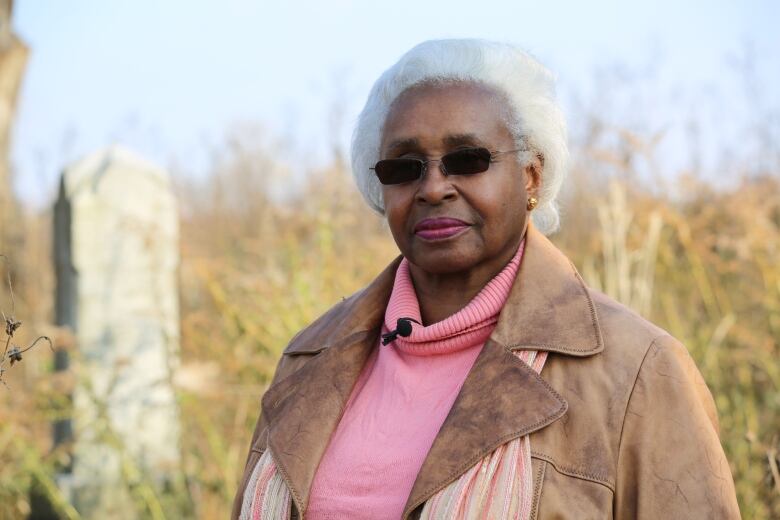 Elise Harding-Davis standing in a graveyard. 