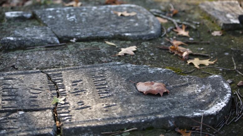 Close up of a tombstone on the ground.