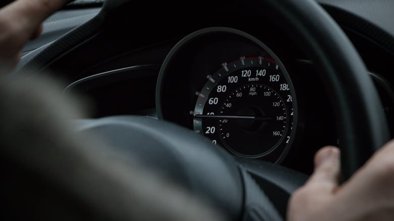 A person with their hands on the steering wheel.