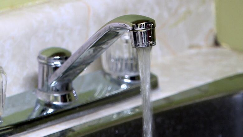 Water coming out of a stainless steel kitchen faucet