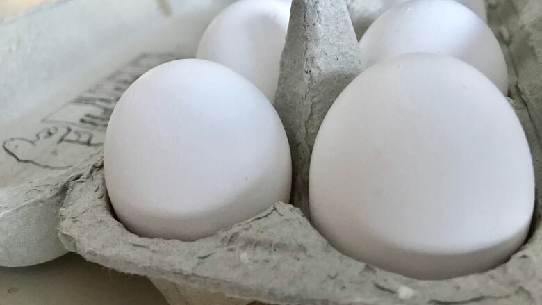 A close up of some eggs in a carton.