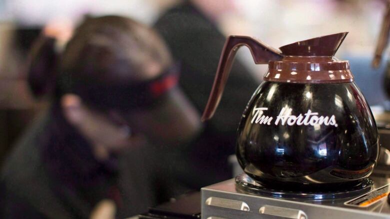 A pot of Tim Hortons coffee sits on a hot plate in a coffee shop. 