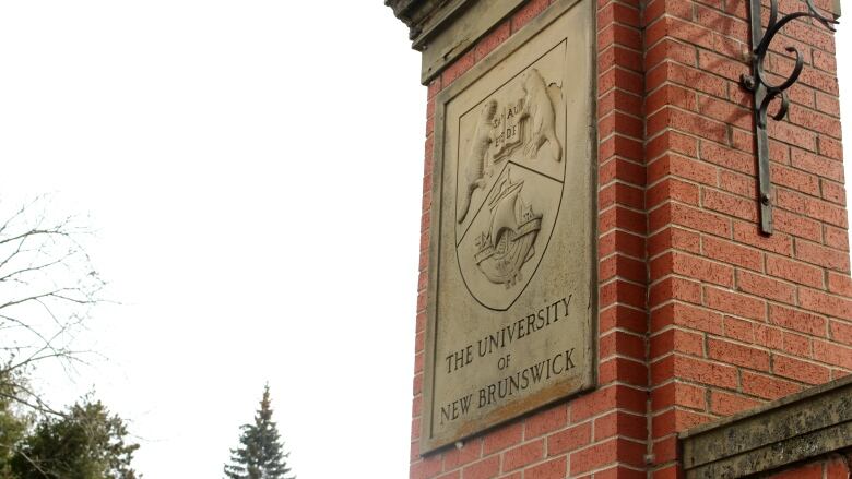 Red brick column with stone plaque. Reads 