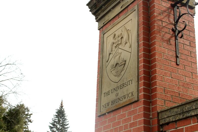 Red brick column with stone plaque. Reads 