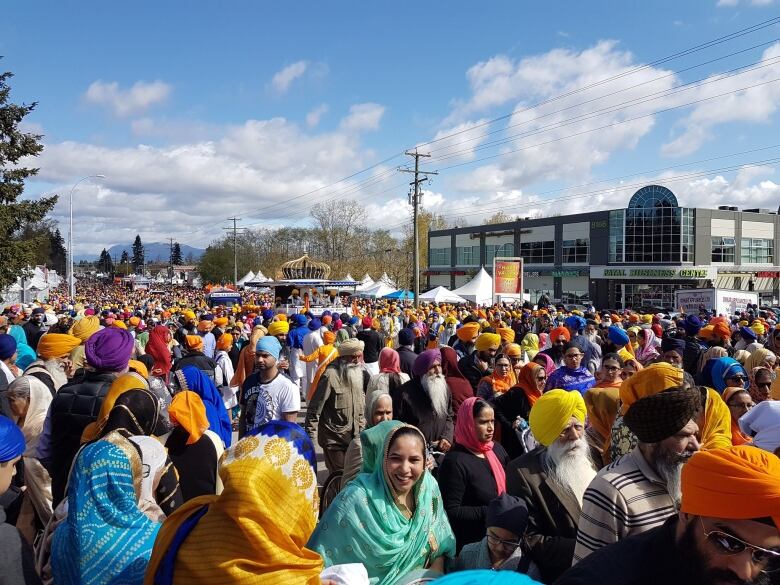 Thousands of people fill a city street.