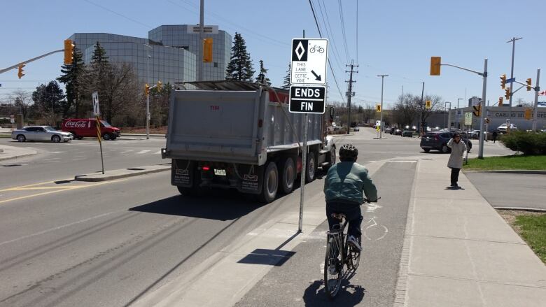 A cyclist reaches the southern limit of the raised cycle track on Churchill Avenue, where they're deposited onto Carling Avenue.