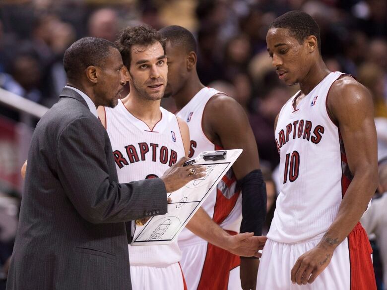 A coach talks to his two players.