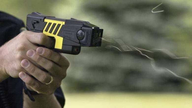 Two hands are pictured discharging a taser.