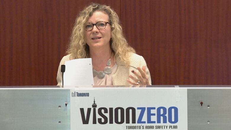 A woman speaks at a podium for Vision Zero.