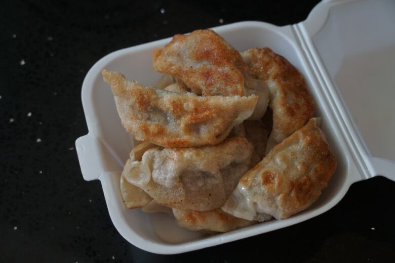 Fried dumplings in a Styrofoam container.