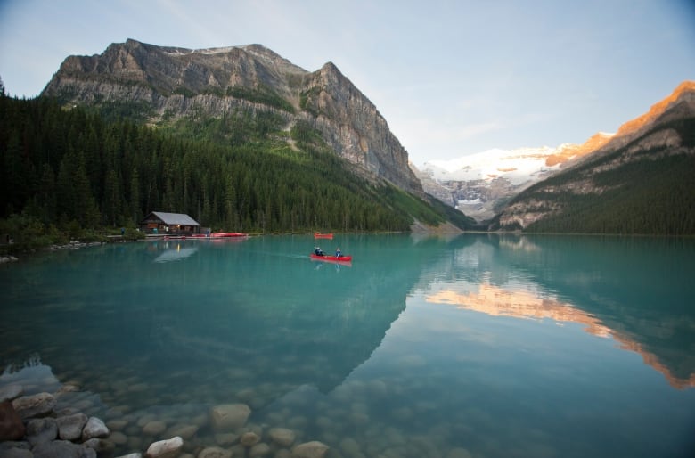 People canoeing across the turquoise waters of Lake Louise.