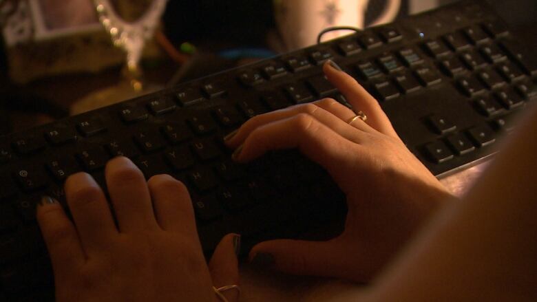 A woman's hands on a keyboard are pictured.