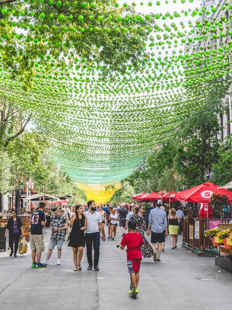 Balls hang above people in the street.