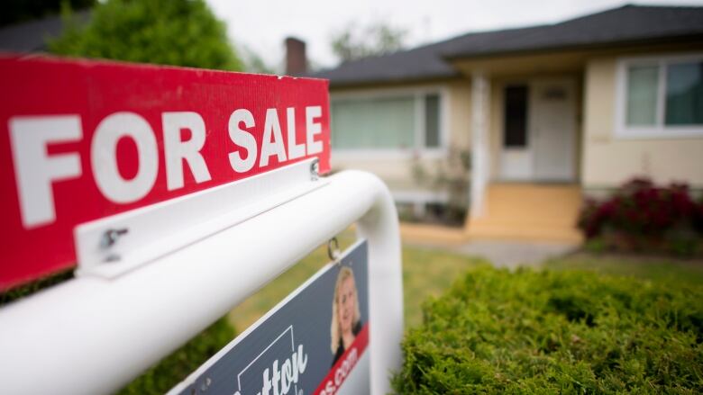 A 'For Sale' sign outside a home.