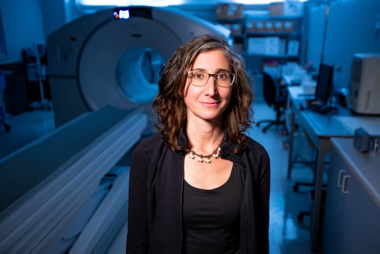 Female psychiatrist stands by a scanner.  