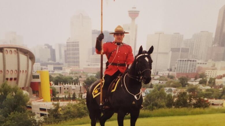 RCMP Sgt. Todd Gray is seen in his RCMP uniform riding a horse. 