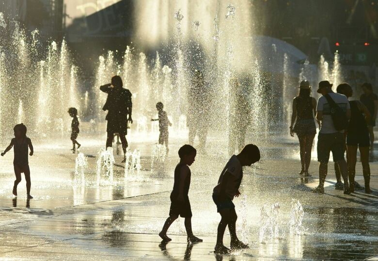 Children play in the water fountains at the Place des Arts in Montreal, Canada on a hot summer day July 3, 2018. (Photo by EVA HAMBACH / AFP)        (Photo credit should read EVA HAMBACH/AFP/Getty Images)