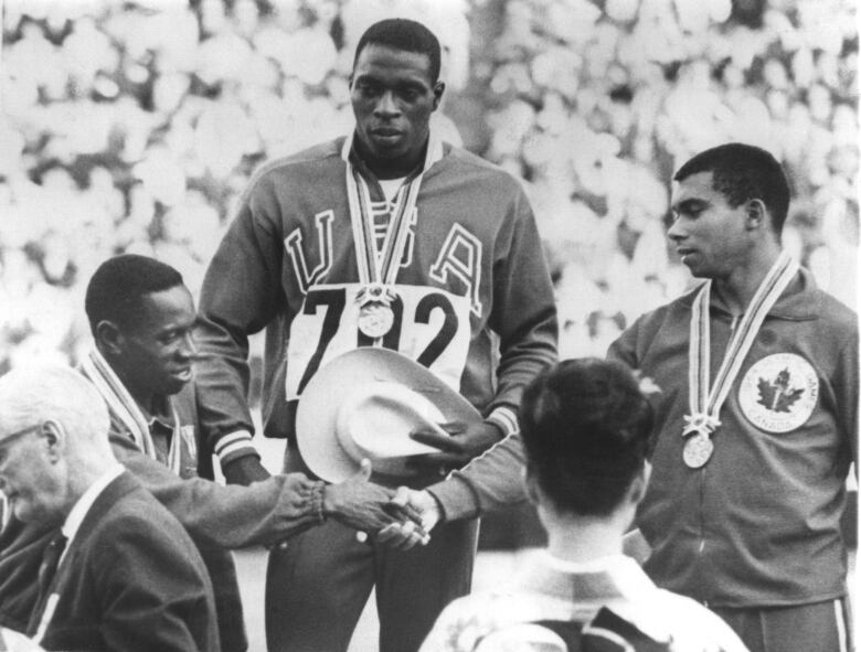 Olympians on podium with medals.