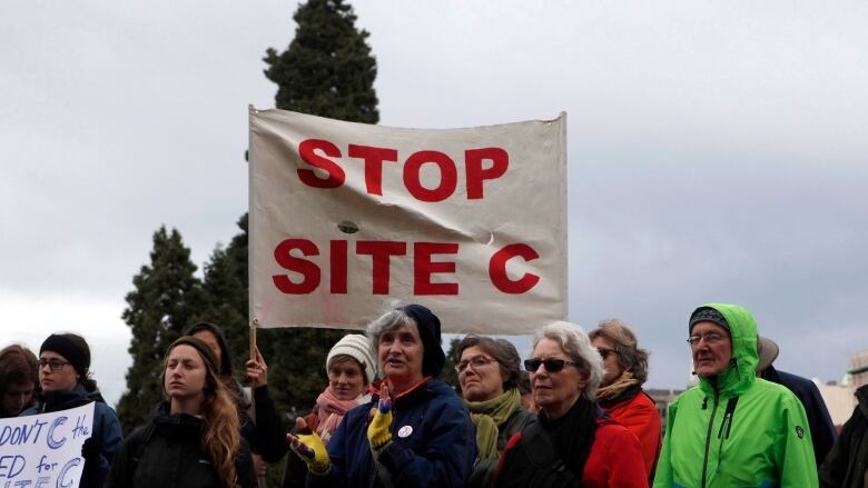 A group of people standing under a banner that says 