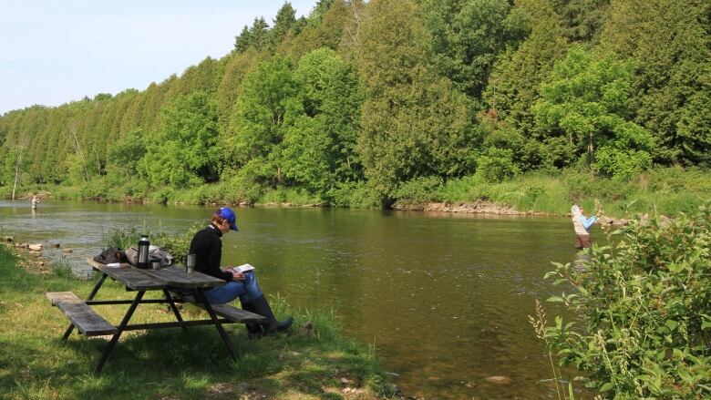 Person reading a book at Bellwood Lake. 