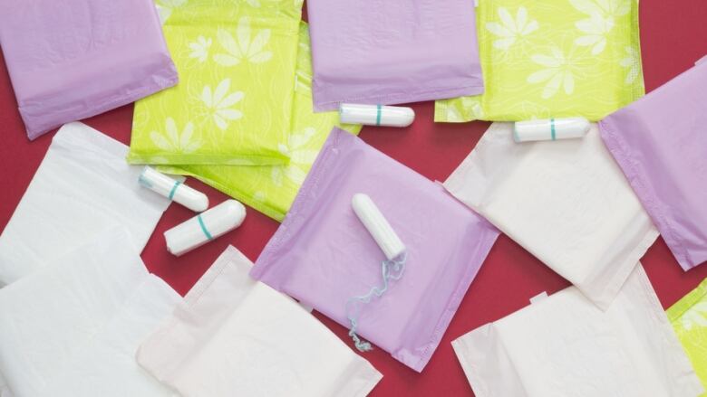 Pads and tampons are seen on a red background.