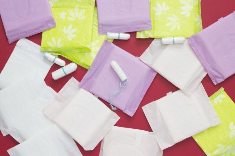 Pads and tampons are seen on a red background.