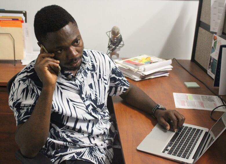 Man on phone with laptop