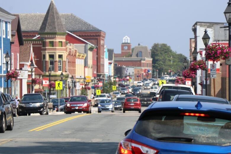 A busy downtown street is full of cars on a sunny day.