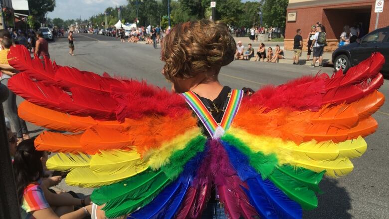 Person wearing rainbow wings