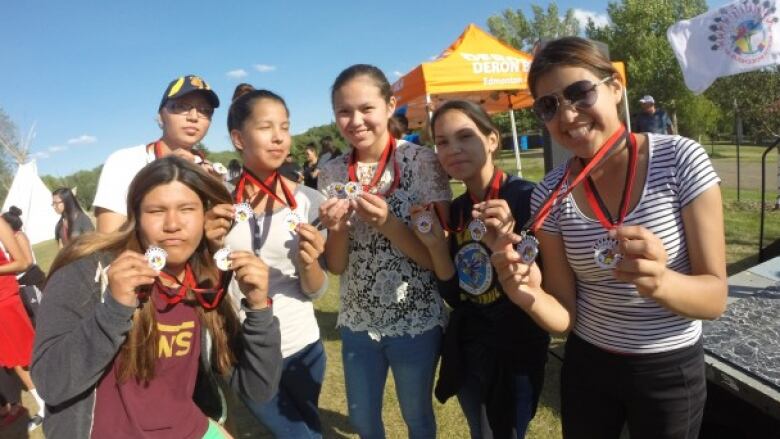 Kids smiling and holding their medals