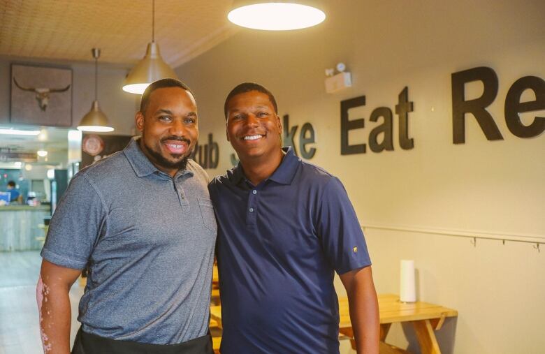 Two men stand in a restaurant