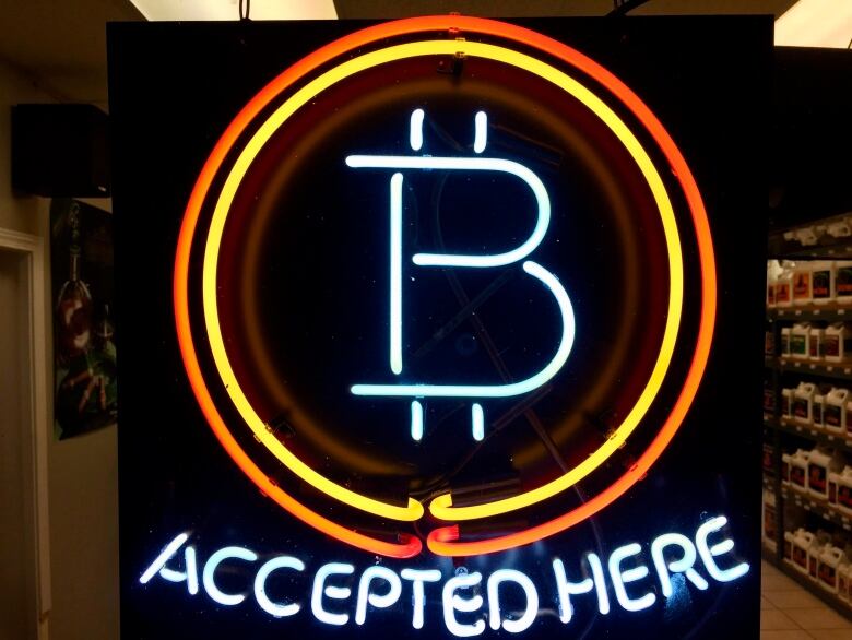 A neon sign indicates that the store accepts the Bitcoin cryptocurrency.