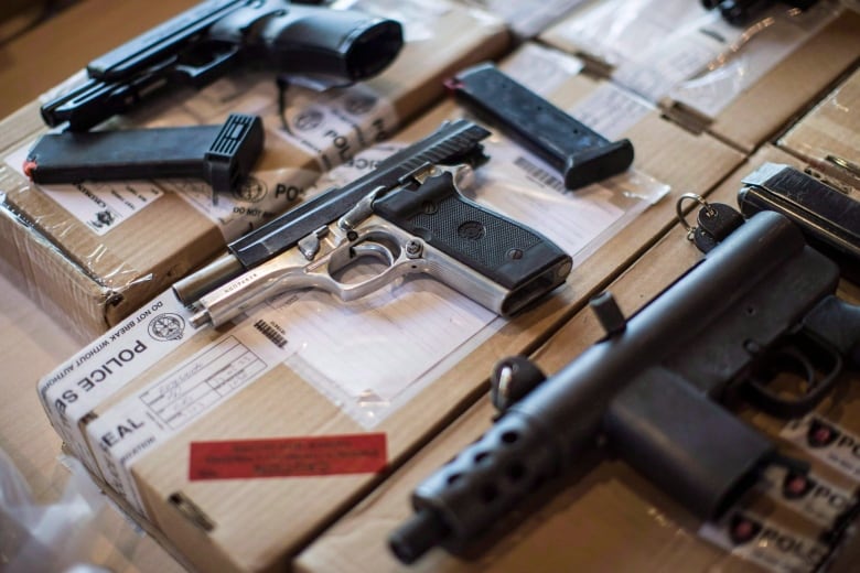 An assortment of guns and magazine clips.