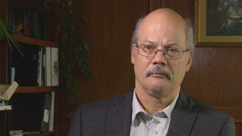 A lawyer in a suit sits in his office.