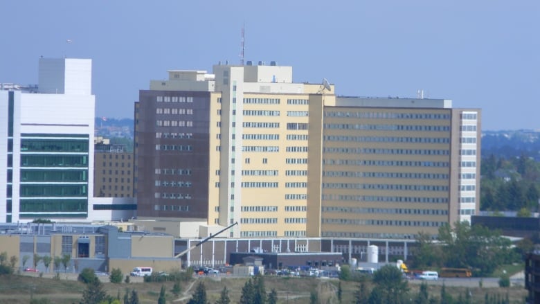 A hospital building is pictured in the distance.