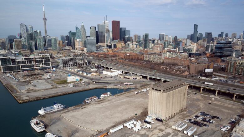 An aerial view of a city waterfront that's largely concrete parking lots and empty space. 