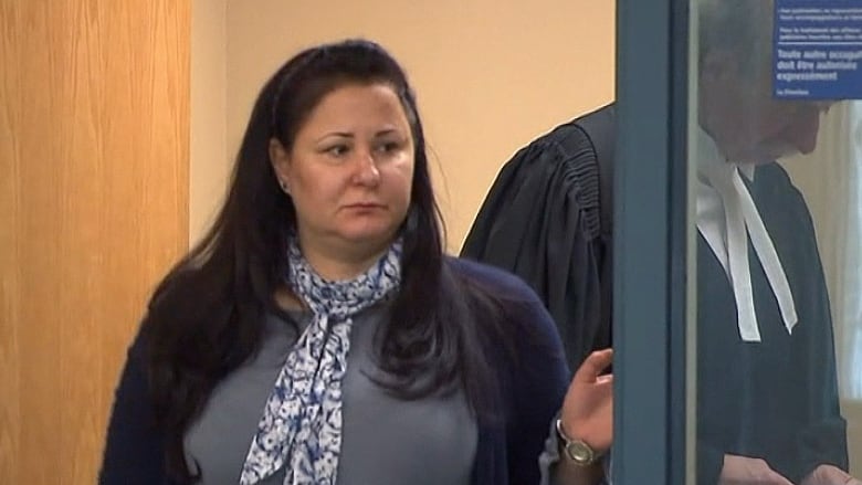 A woman leaves a courtroom.