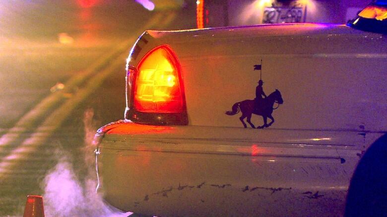 The back of a police car, with clip art of a Mountie on a horse.