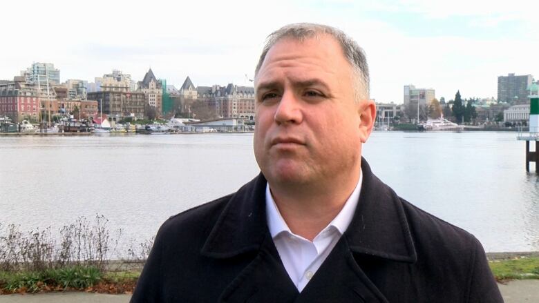 A man standing in front of a body of water in Victoria.