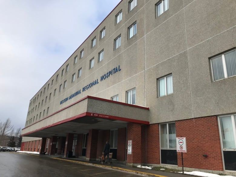 A concrete and bricks building bears the words Western Memorial Regional Hospital in blue lettering. 