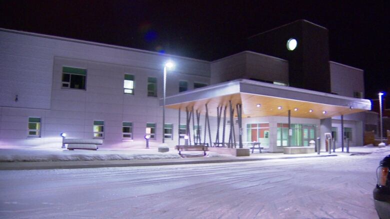 A hospital is seen from the outside on a winter's night.