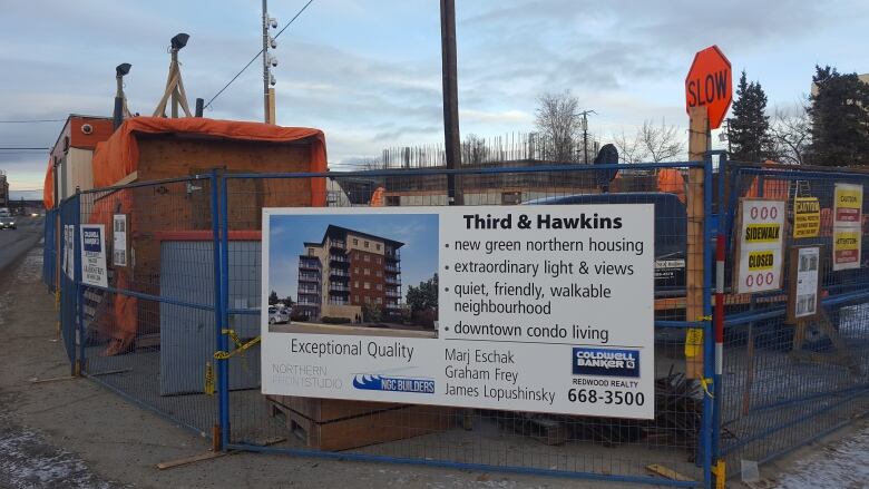 A sign and fence around a construction site.