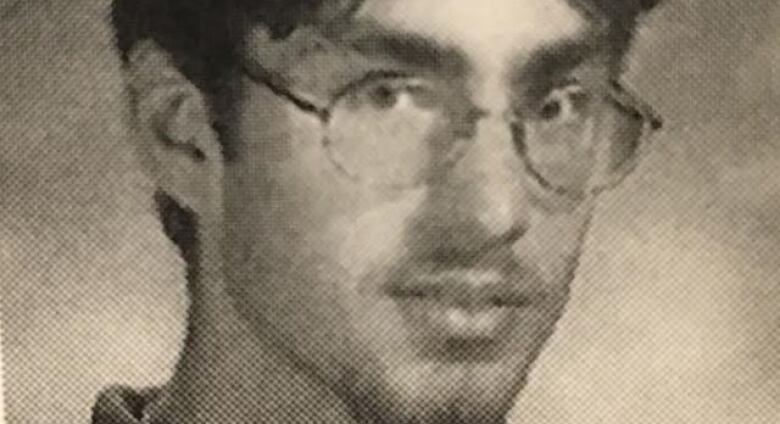 In a black and white headshot, Steve Wright has hair parted down the middle, a mustache and goatee and is wearing glasses. 