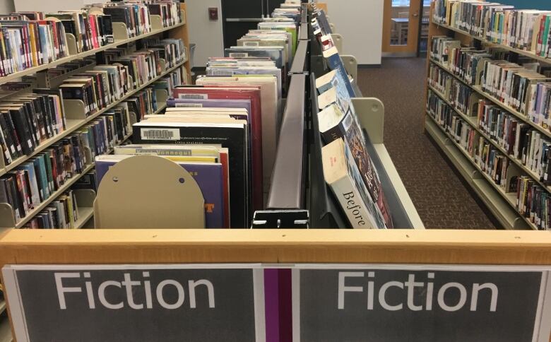 Books on shelves in the fiction section at a library