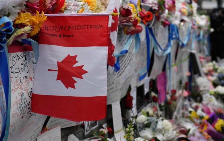 Signs are left at a vigil on Yonge Street in Toronto for the victims of the 2018 van attack in Toronto.